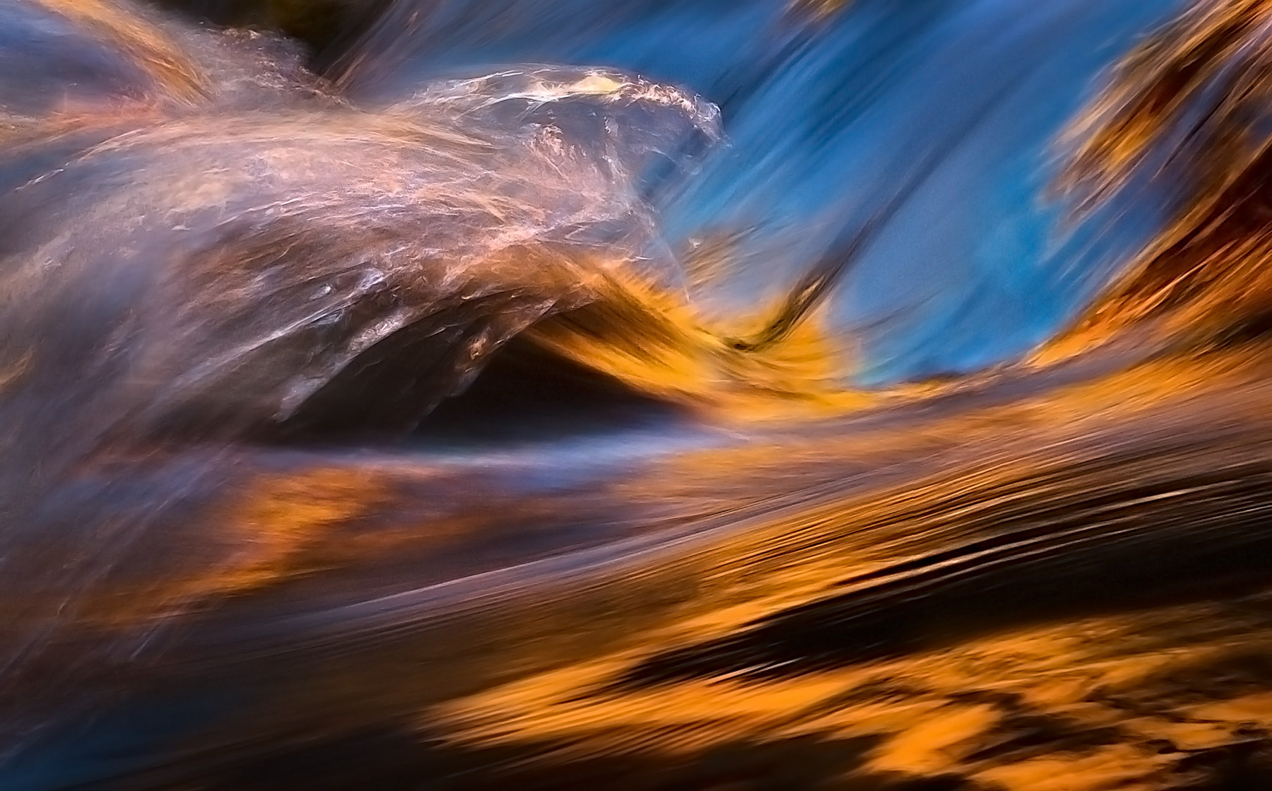 Reflected sandstone gold and blue skies captured by water motion in Zion, Utah.