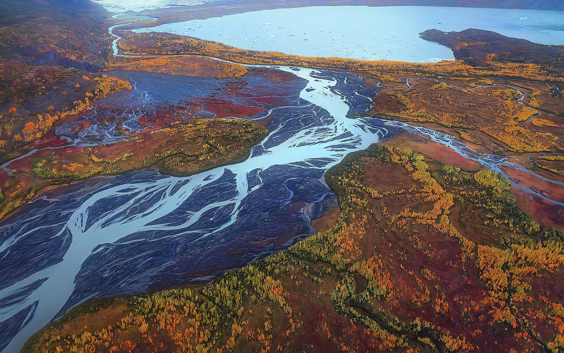 Glacial rivers spill through an array of autumn colors and into an iceberg filled lake at the foot of a glacier.  Only in Alaska...