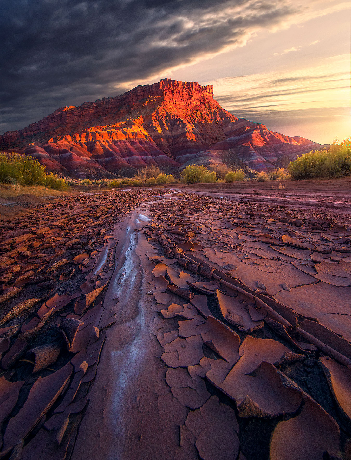 A salt-stained dried wash beneath colorful badlands in Arizona near sunset.