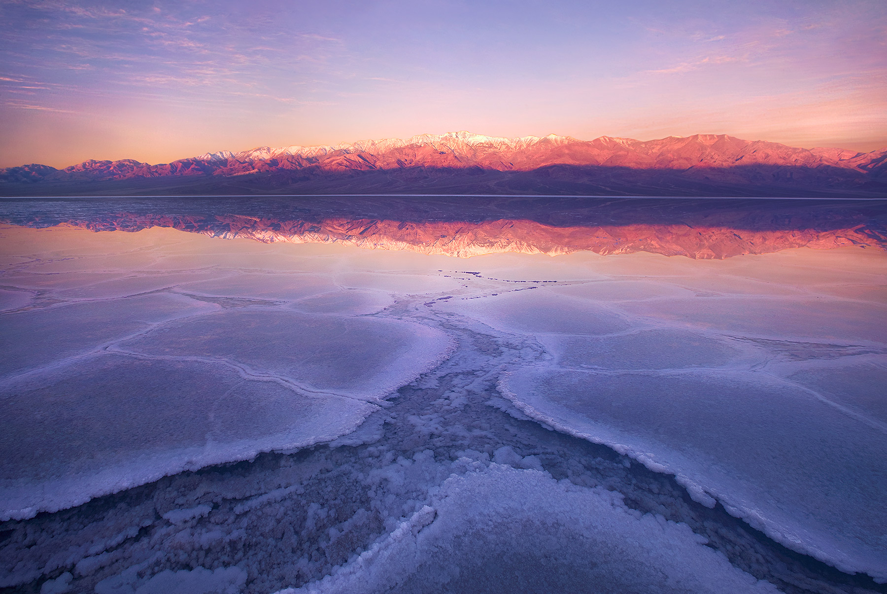 Underwater salt crystal formations photographed at sunrise stretch across Badwater, the lowest point in North America in Death...