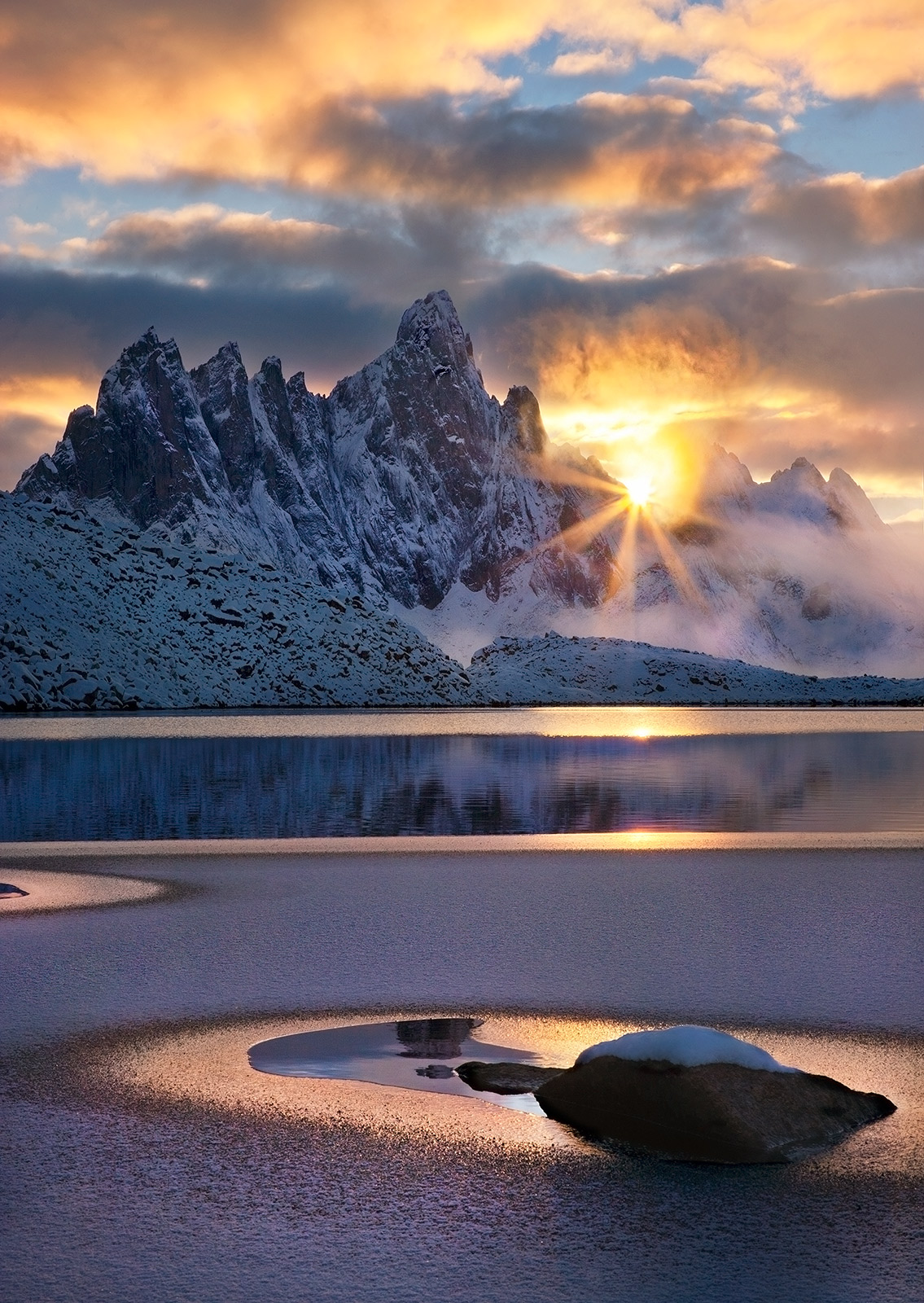 The darkened face of Tombstone mountain lords over this frozen valley in early winter in Canada's north.