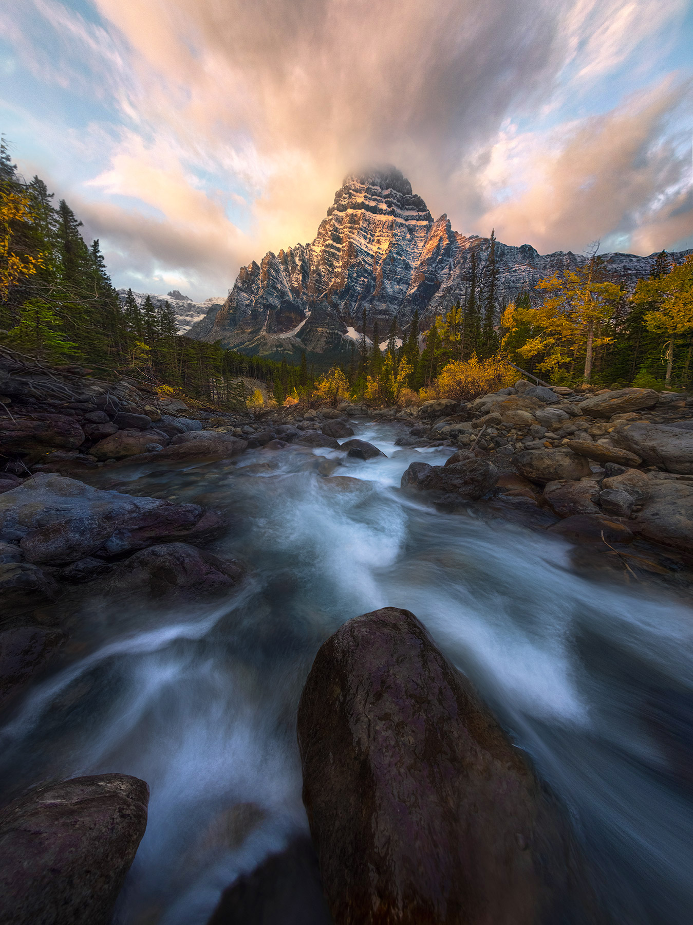 Rushing cascades through fall colors and morning light on the peaks after a new snowfall the night before, Canadian Rockies