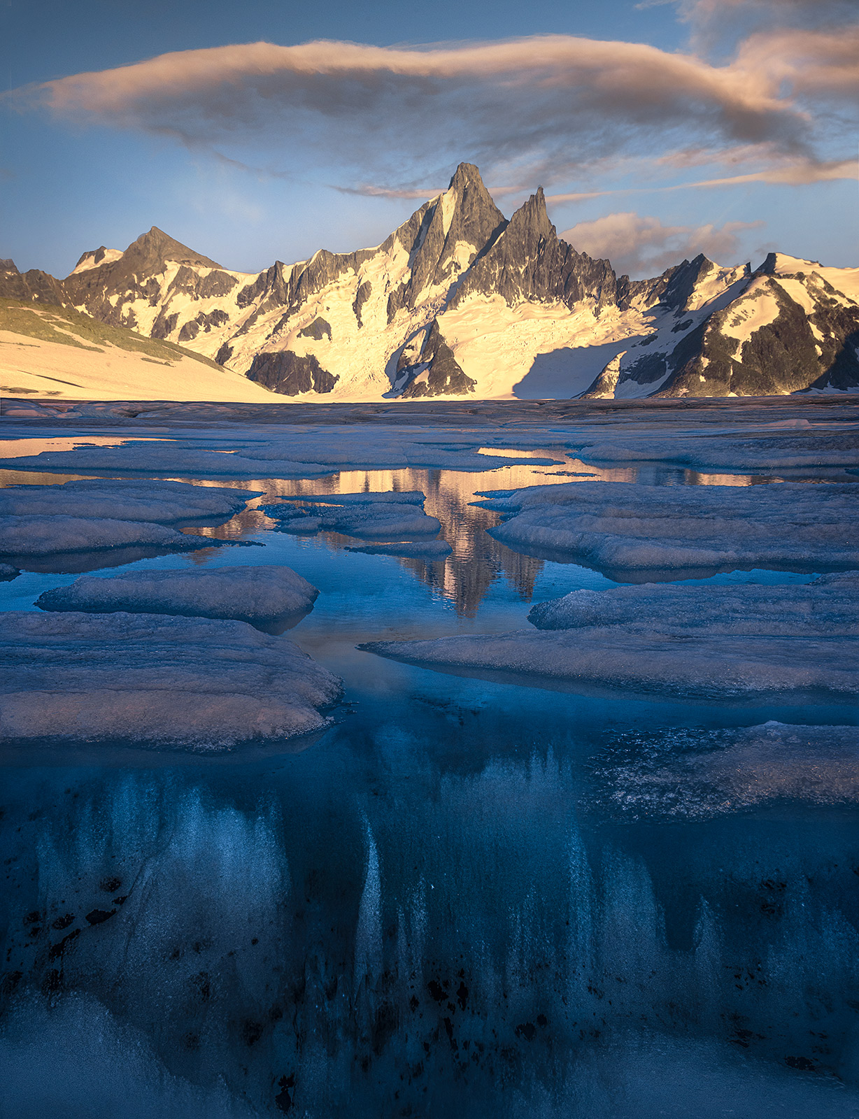 Unusual underwater formations in this glacial pool at sunset in Alaska beneath amazing, jagged mountains.