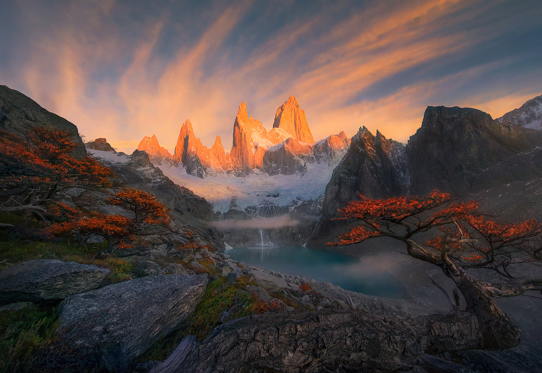 Icefall from a mountain glacier pours into a lake below Fitz Roy, which is arguably the world's most impressive mountain and...