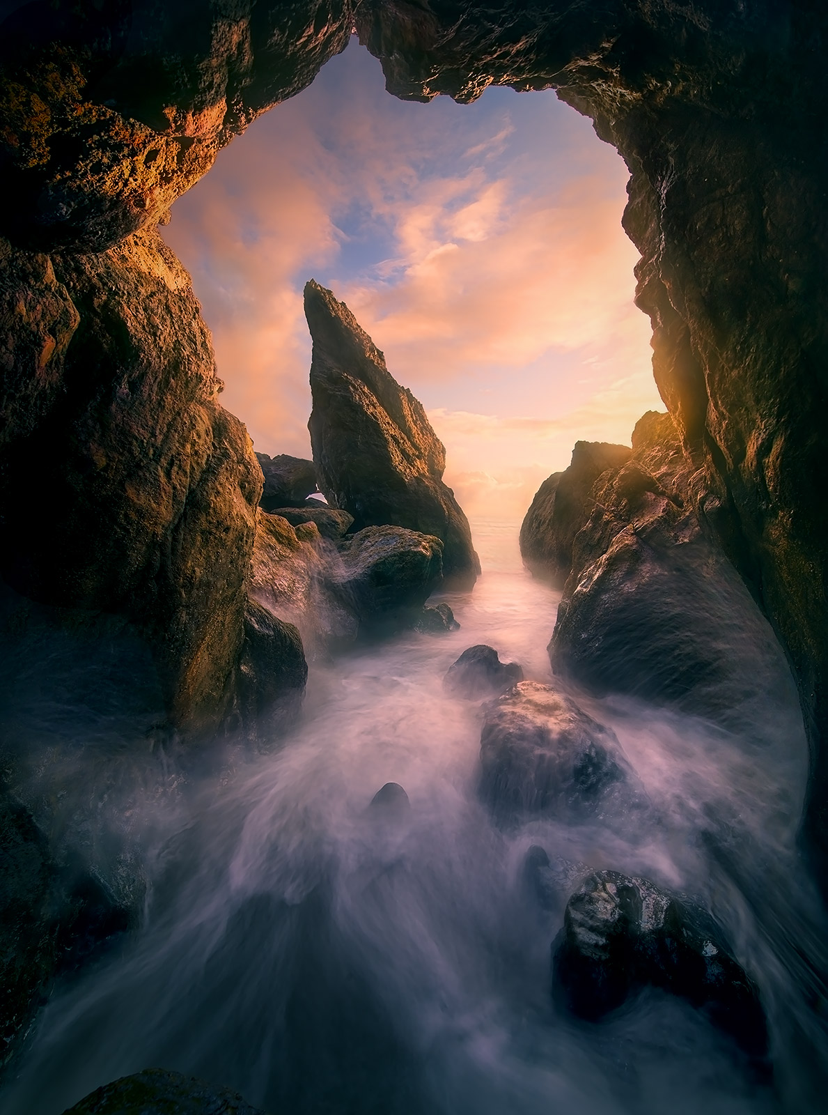 Sunset light and waves inside an ocean cave in Washington.&nbsp;