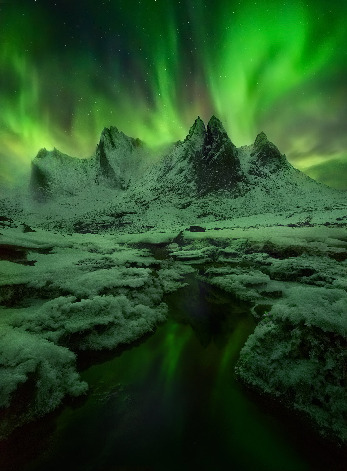 Green Mists (2012) Mist and low clouds pouring through some of the amazing snowy cliff faces in the Yukon's Ogilvie Mountains, with the Aurora overhead...