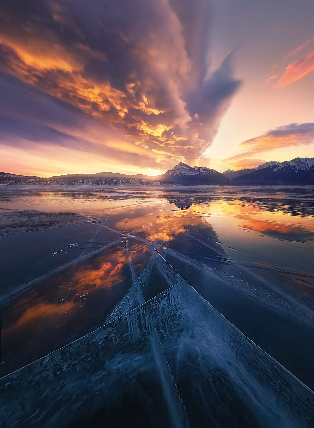 An amazing lenticular wave cloud lights up at sunrise and is reflected in a cracked mirror of glassy ice