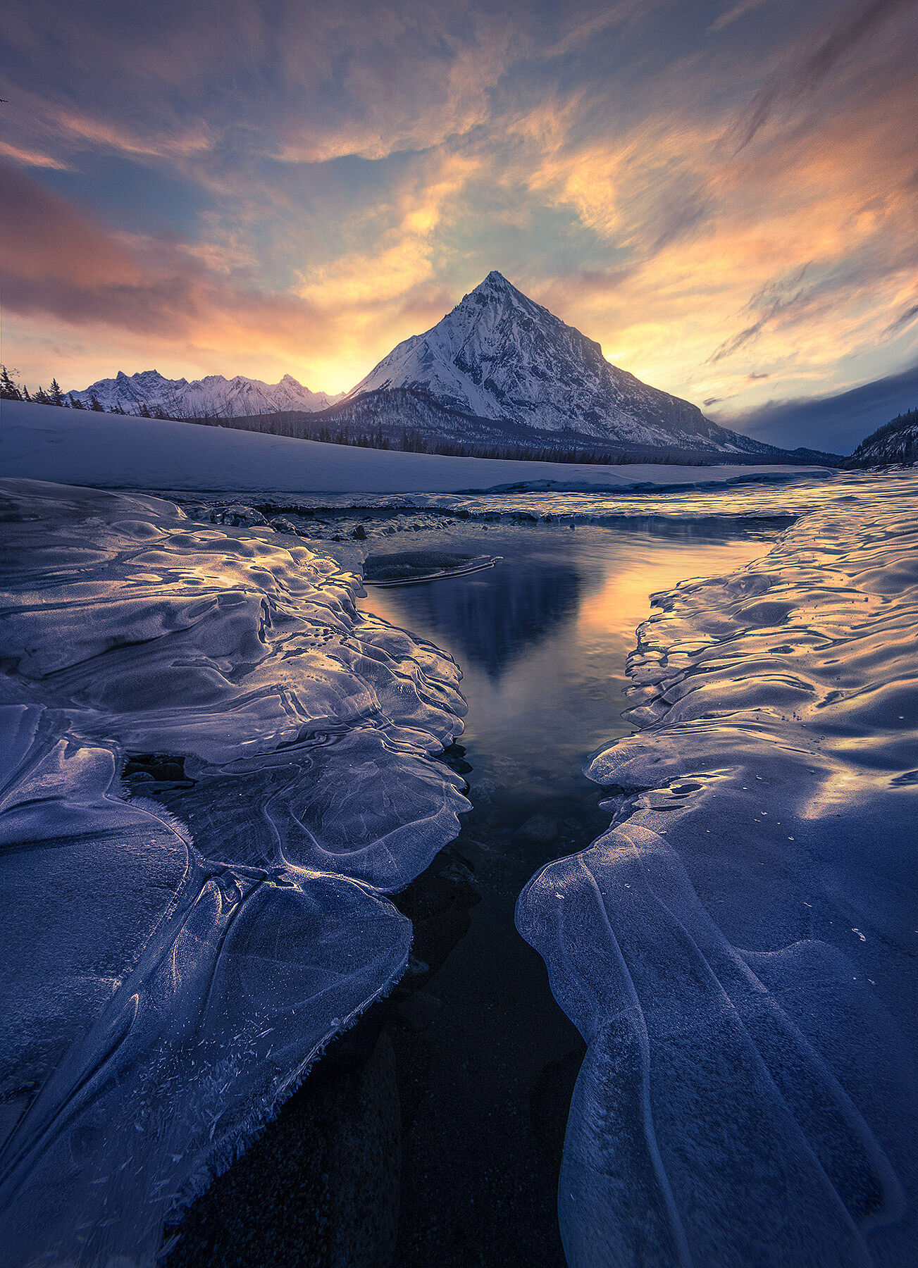 Icy waters reflecting some beautiful light over this sharp Alaskan peak in winter