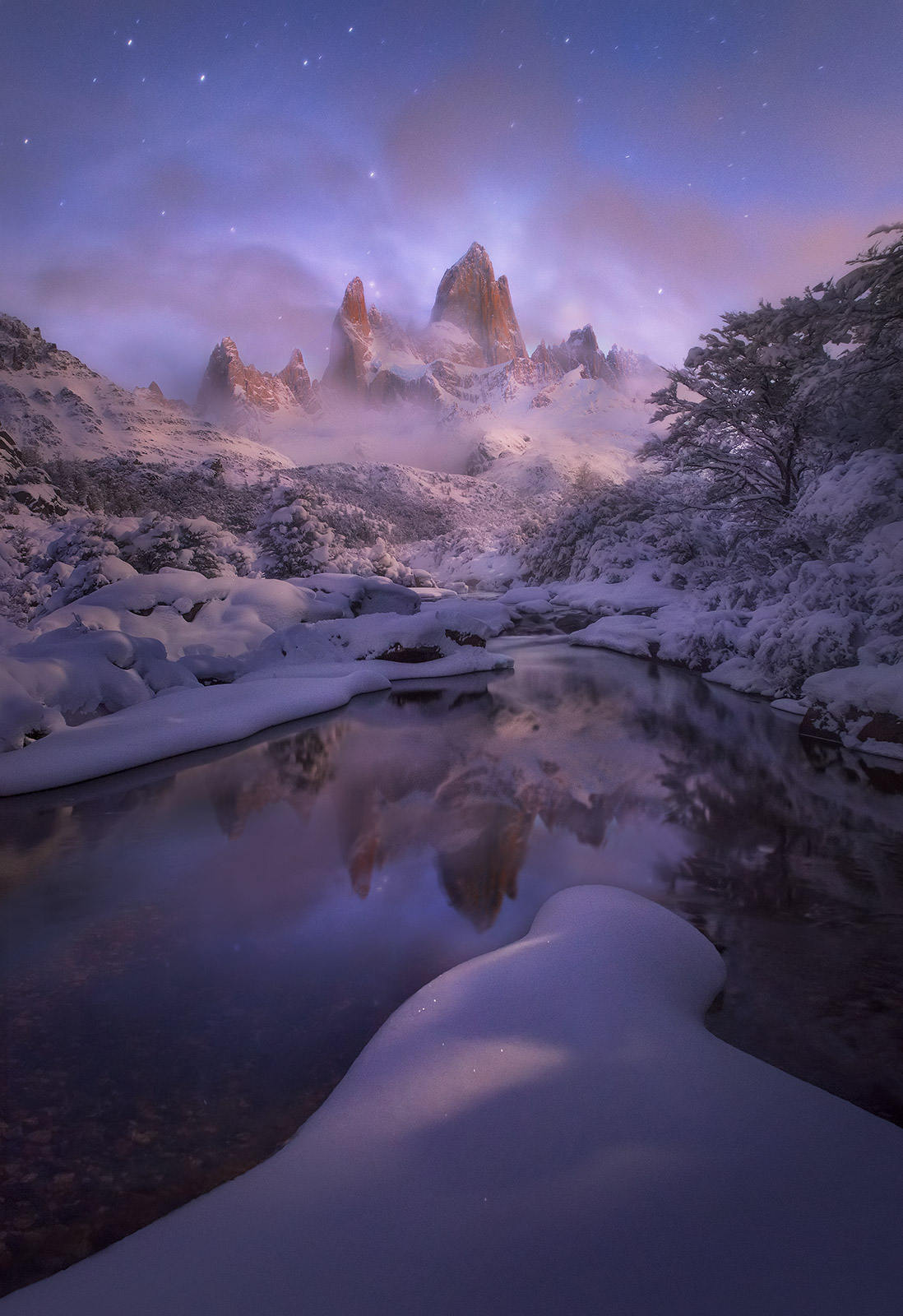 Soft moonlight illuminates a clearing Fitz Roy peak in Patagonia after a heavy winter snowfall.&nbsp;