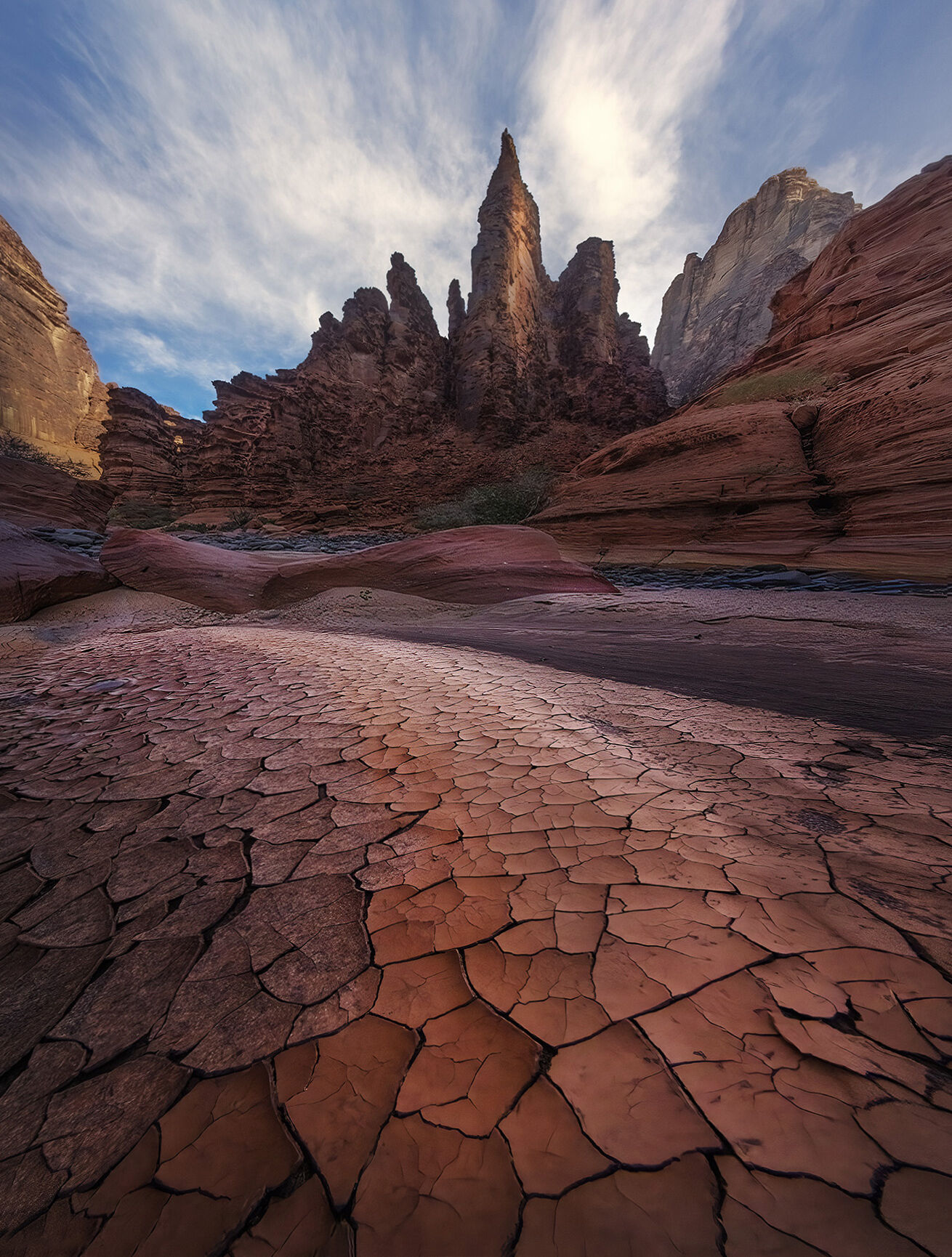 Multi-colored mud patterns deep in a canyon below high peaks in Saudi Arabia's Tabuk region