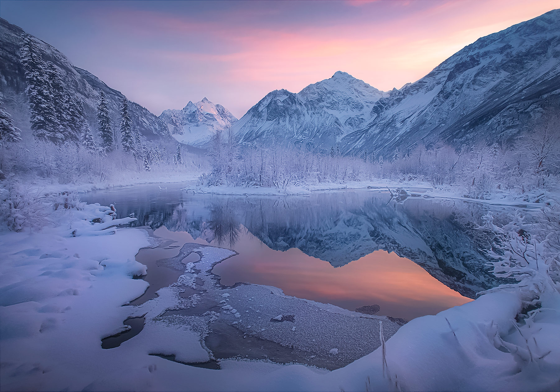 Peaks in Alaska catch the soft winter's light reflected in warm groundwater pools.