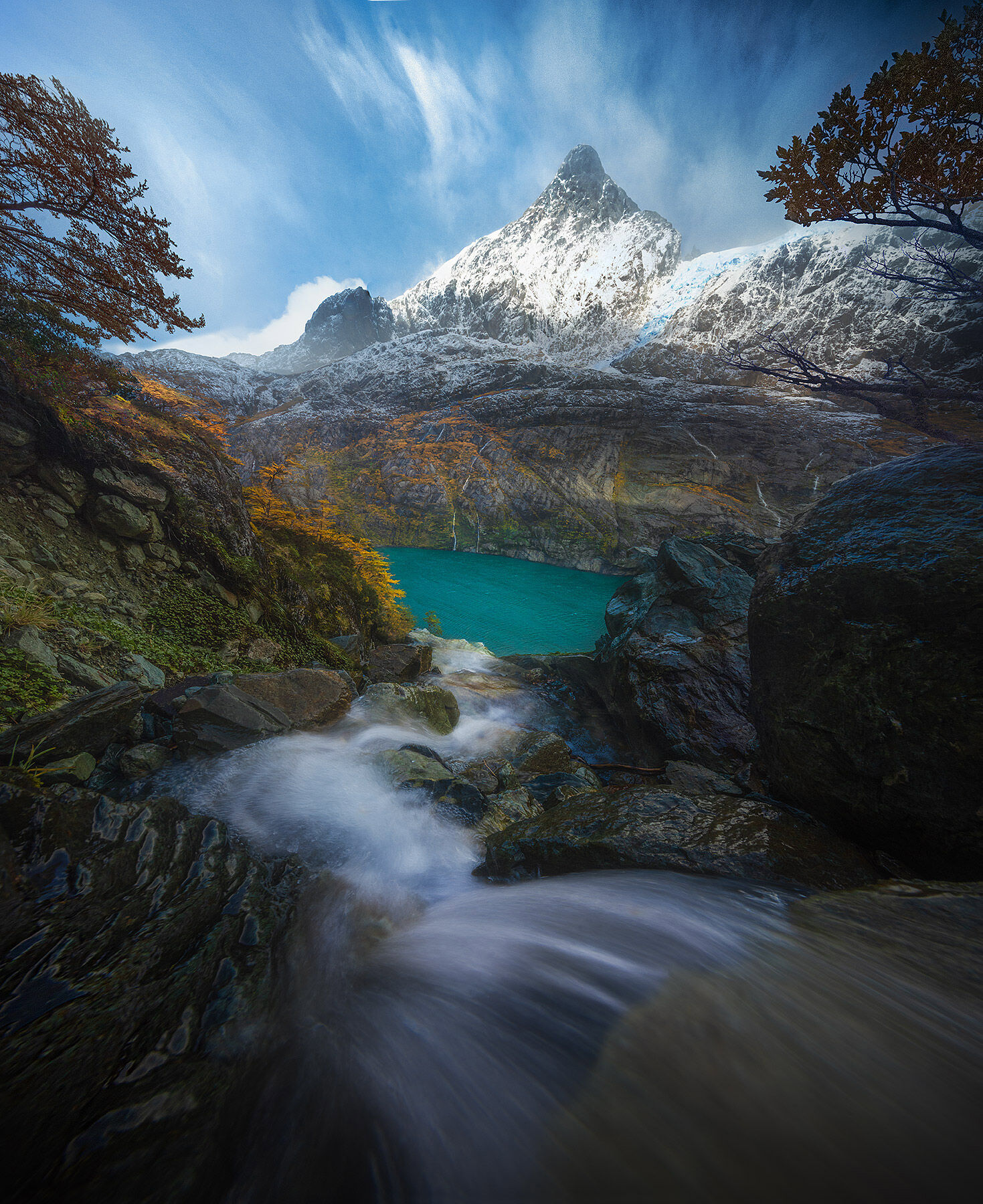 Water rushes down toward a glacial turquoise fjord in Patagonia