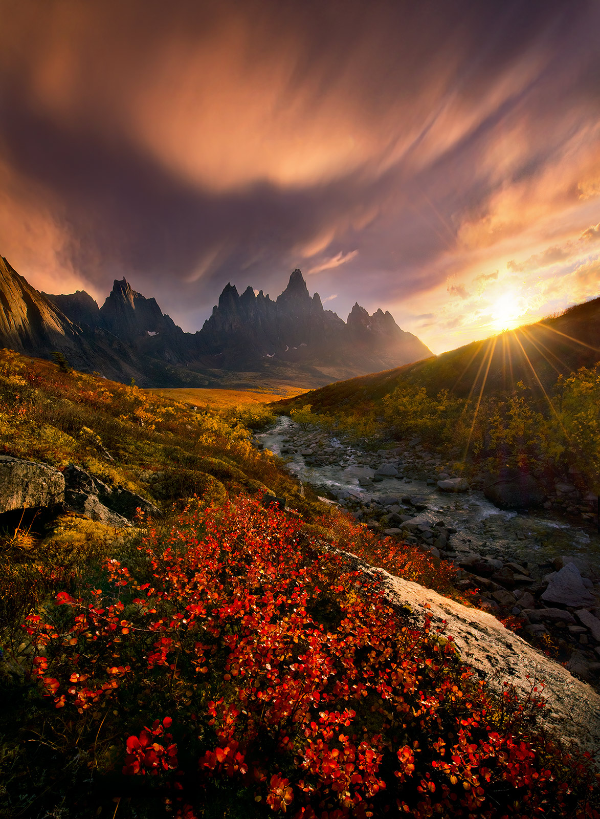 Fiery clouds photographed over dramatic Yukon peaks at sunset. Following a thunderstorm, the skies were illuminated from underneath...