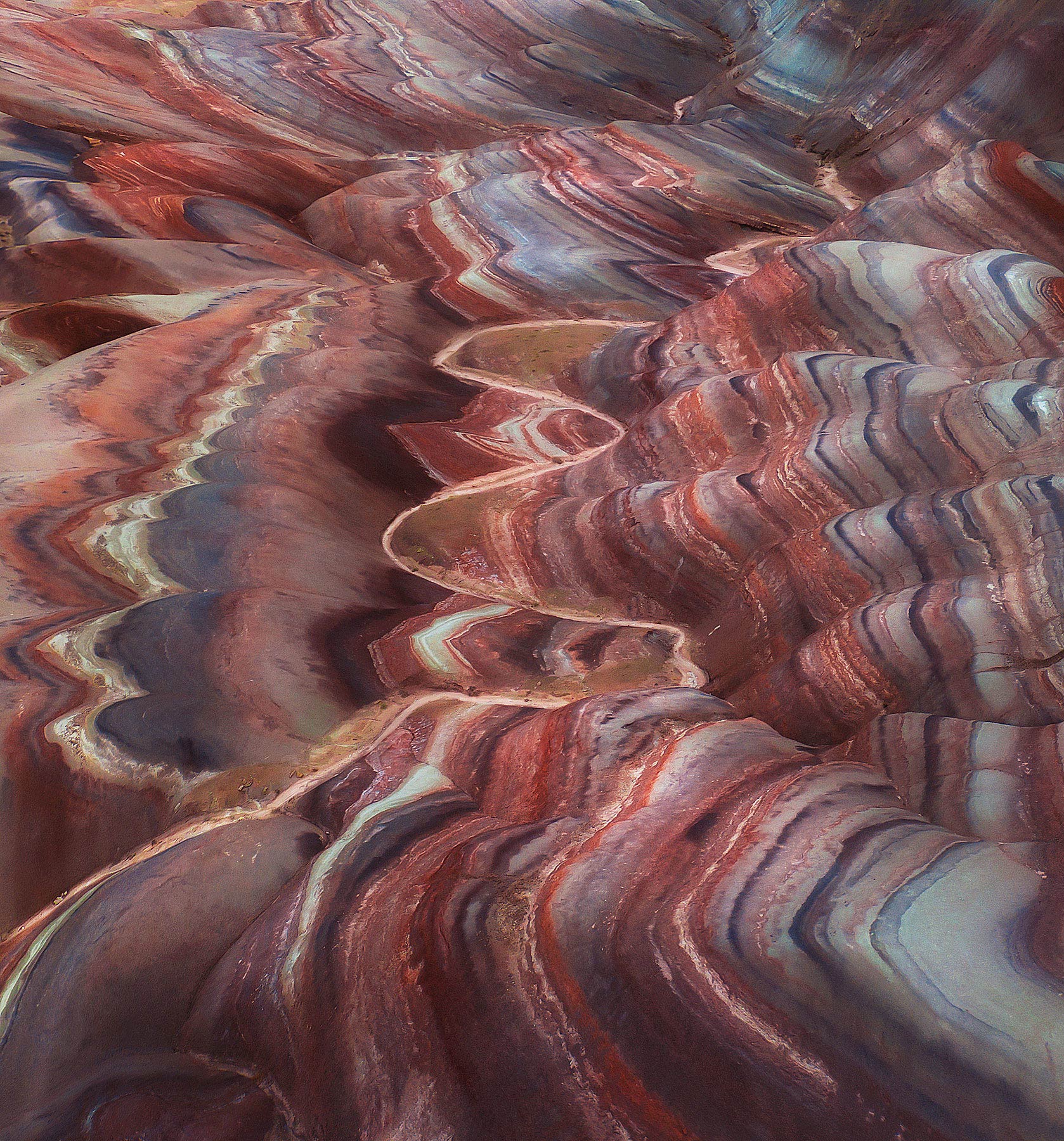 A wash cuts through layers of colorful badlands in the desert Southwest