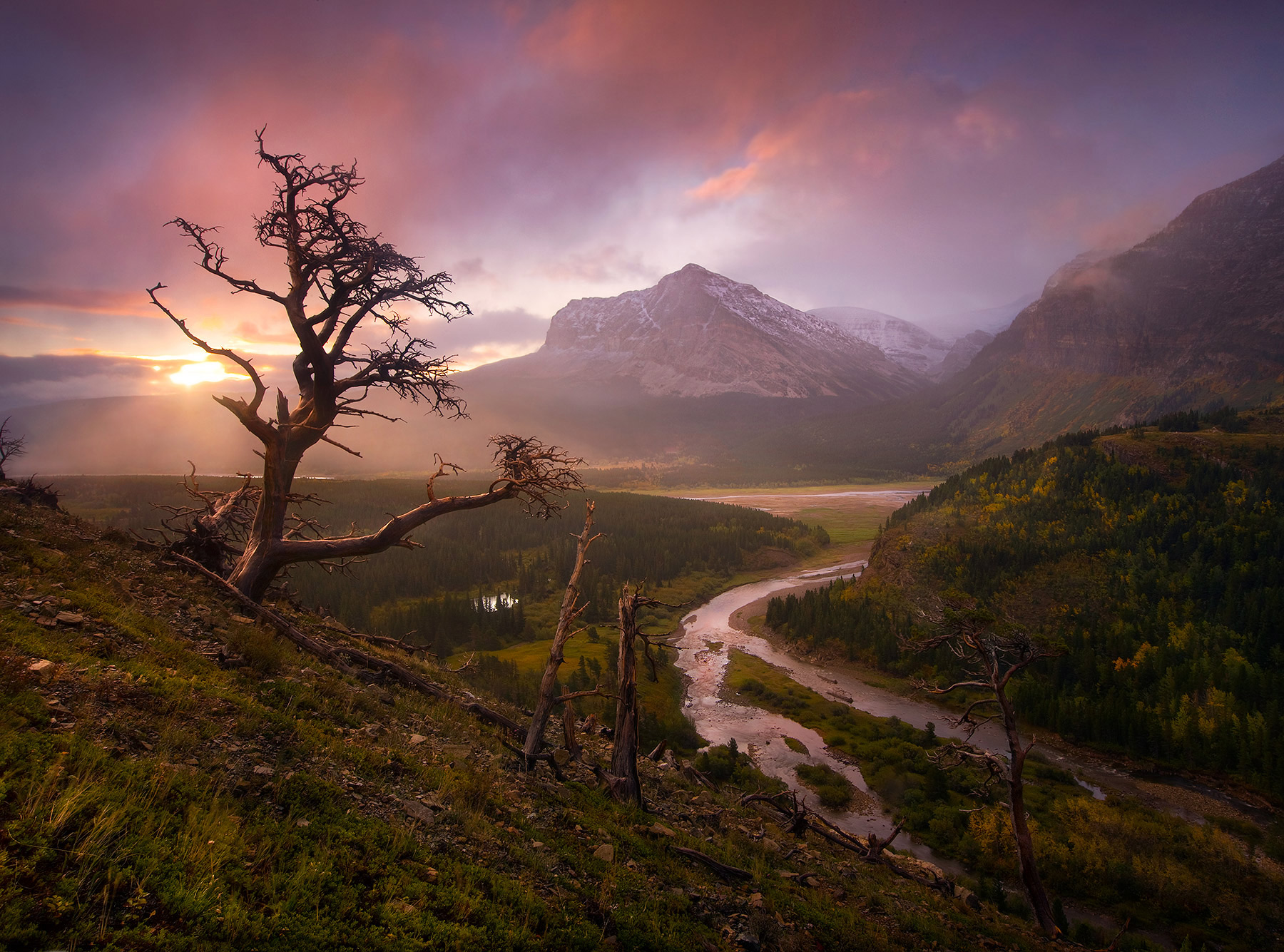 A clearing autumn storm reveals the Eastern peaks of Glacier National Park at sunrise.