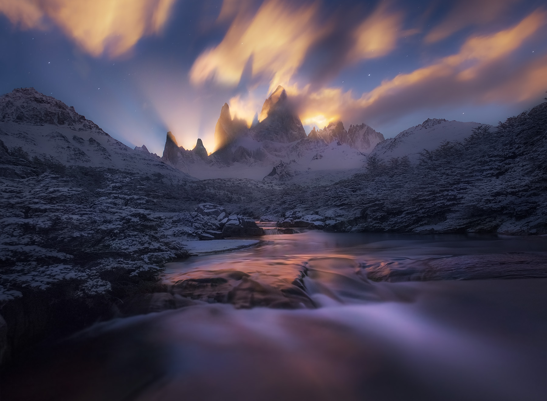 The beams of the moon light up the skies over a snowy landscape below the world's greatest mountain, Fitz Roy, in Argentina. &...