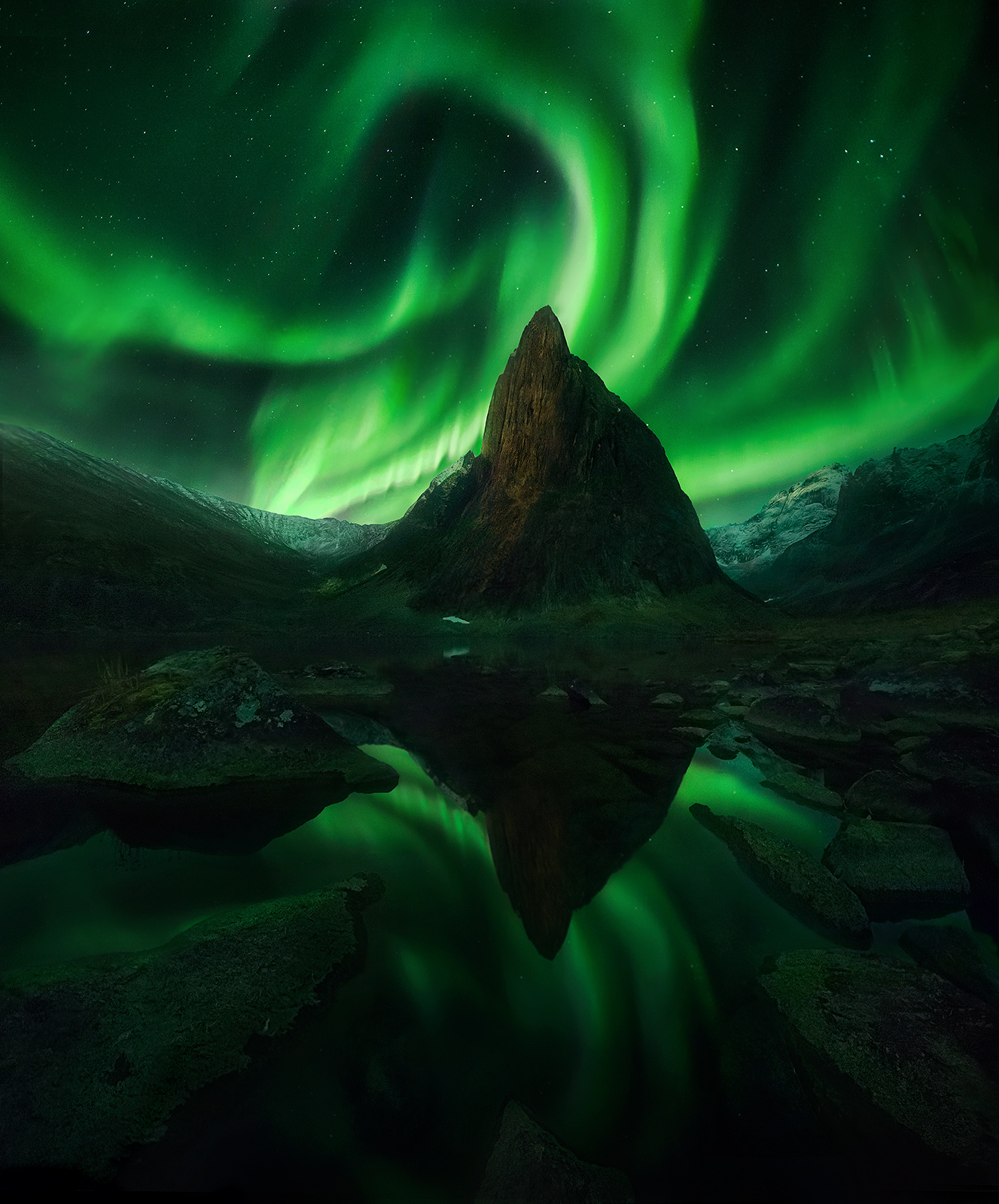 Shark's Tooth peak reflected under the light the aurora and rising moon.&nbsp;