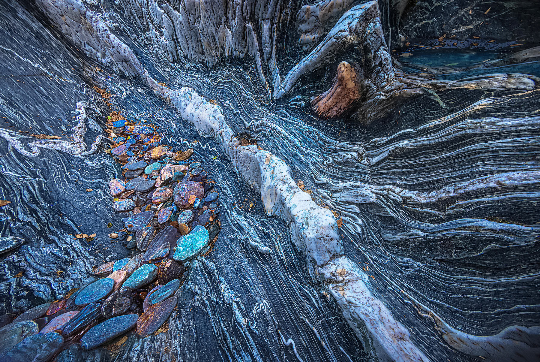 Amazing polished Shist rock and various pebbles along the river canyon in New Zealand.