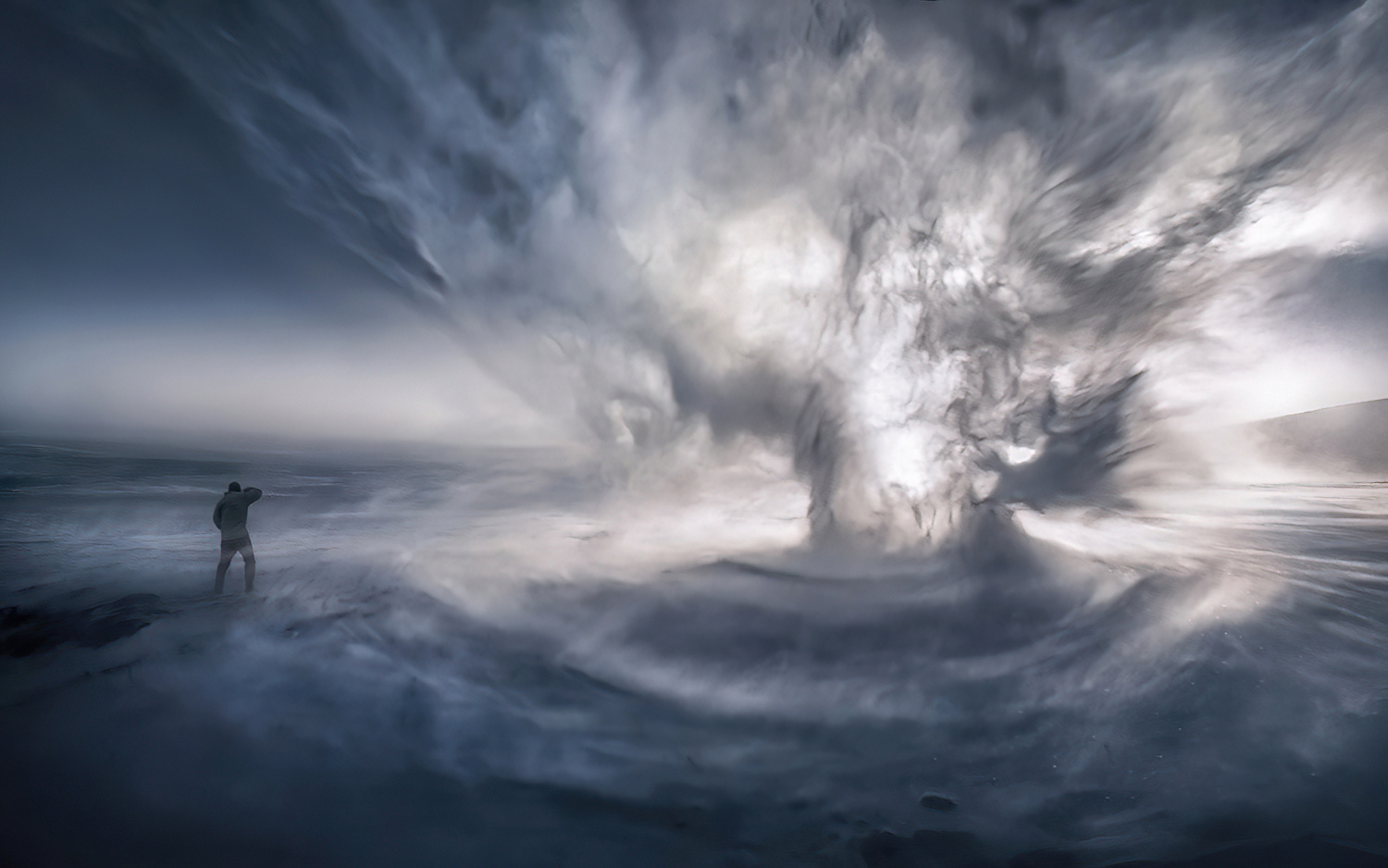 What you are looking at here is a photograph including a spindrift whirlwind (like a 'dust devil' or real tornado, this is simply...