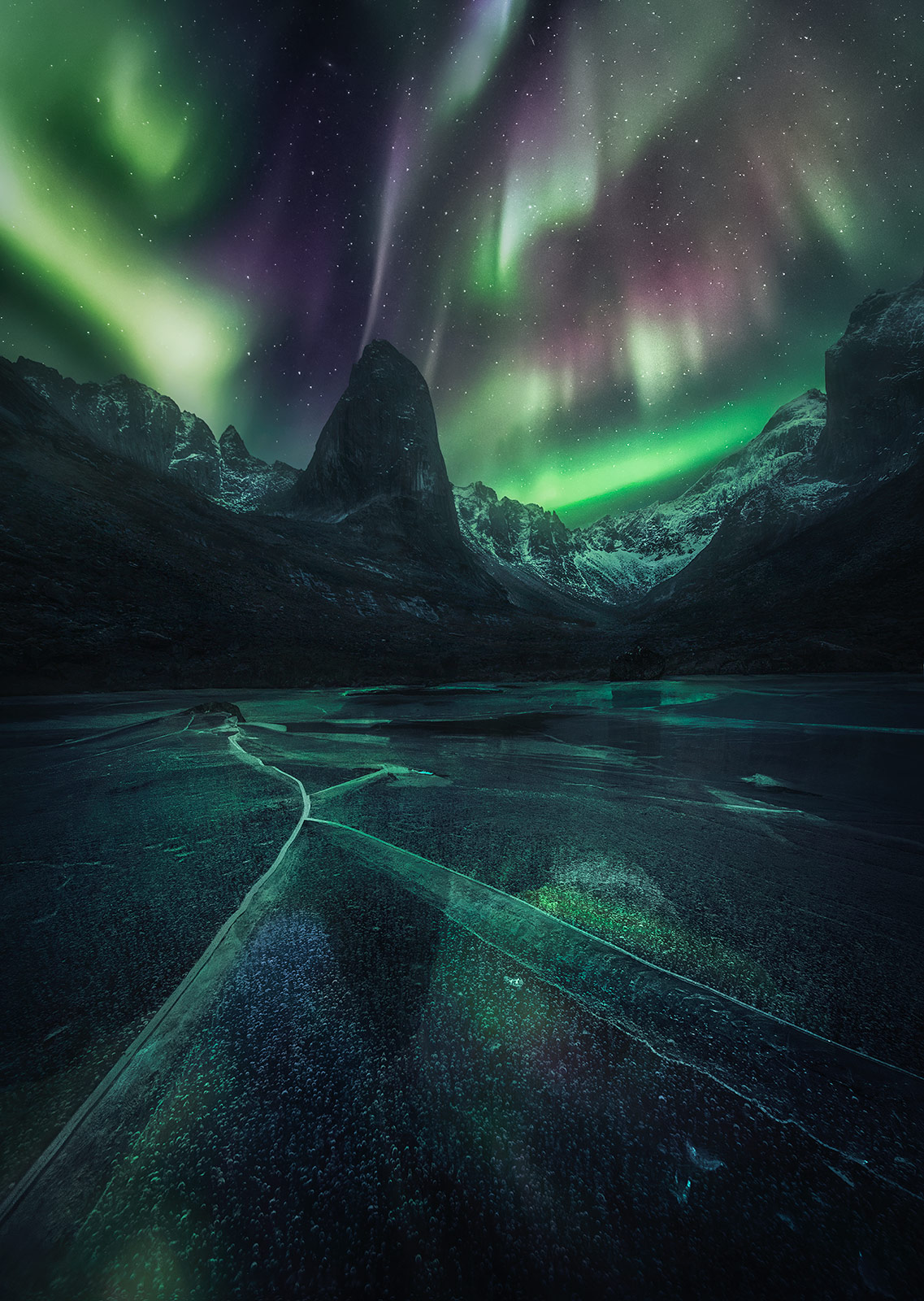 A remarkable aurora photographed deep in the mountains of the Arctic Yukon which is reflected in clear ice surface near our nightly...