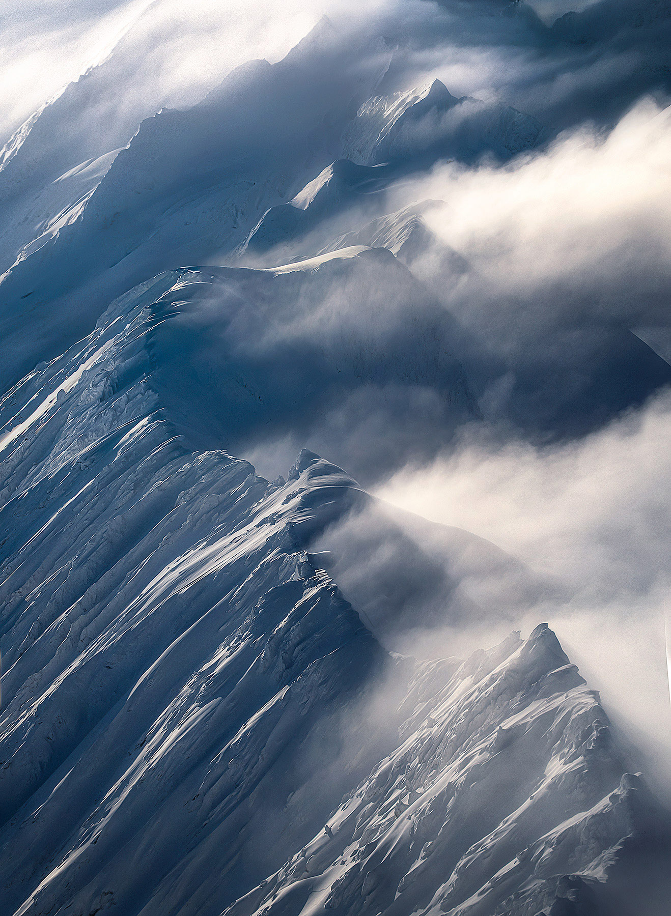 Layers of frozen peaks across summit ridges high in the Chugach Range in winter.