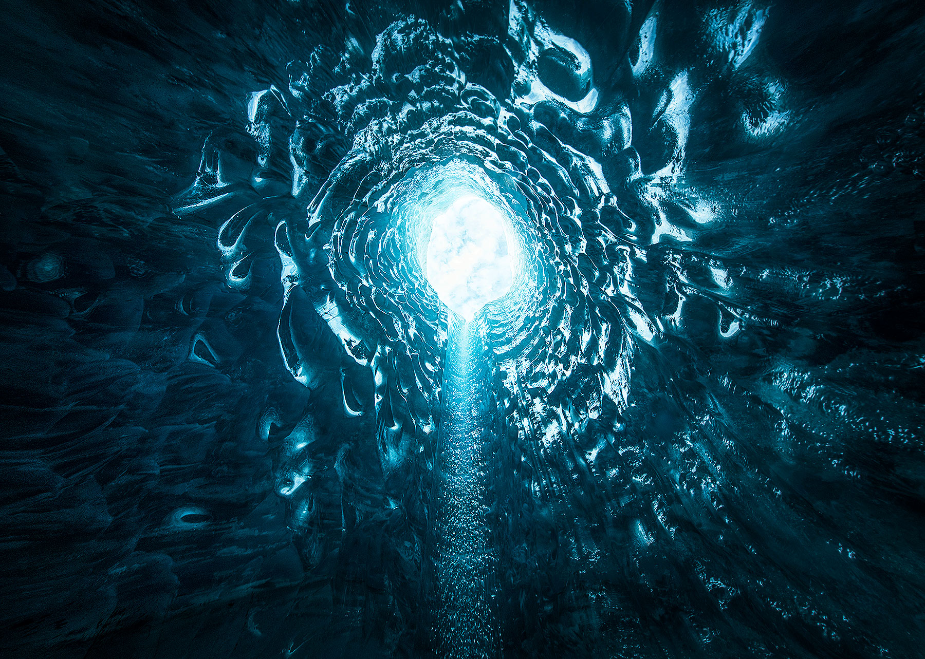 Looking up a Moulin, a vertical tube of ice inside a glacier in Alaska.&nbsp;