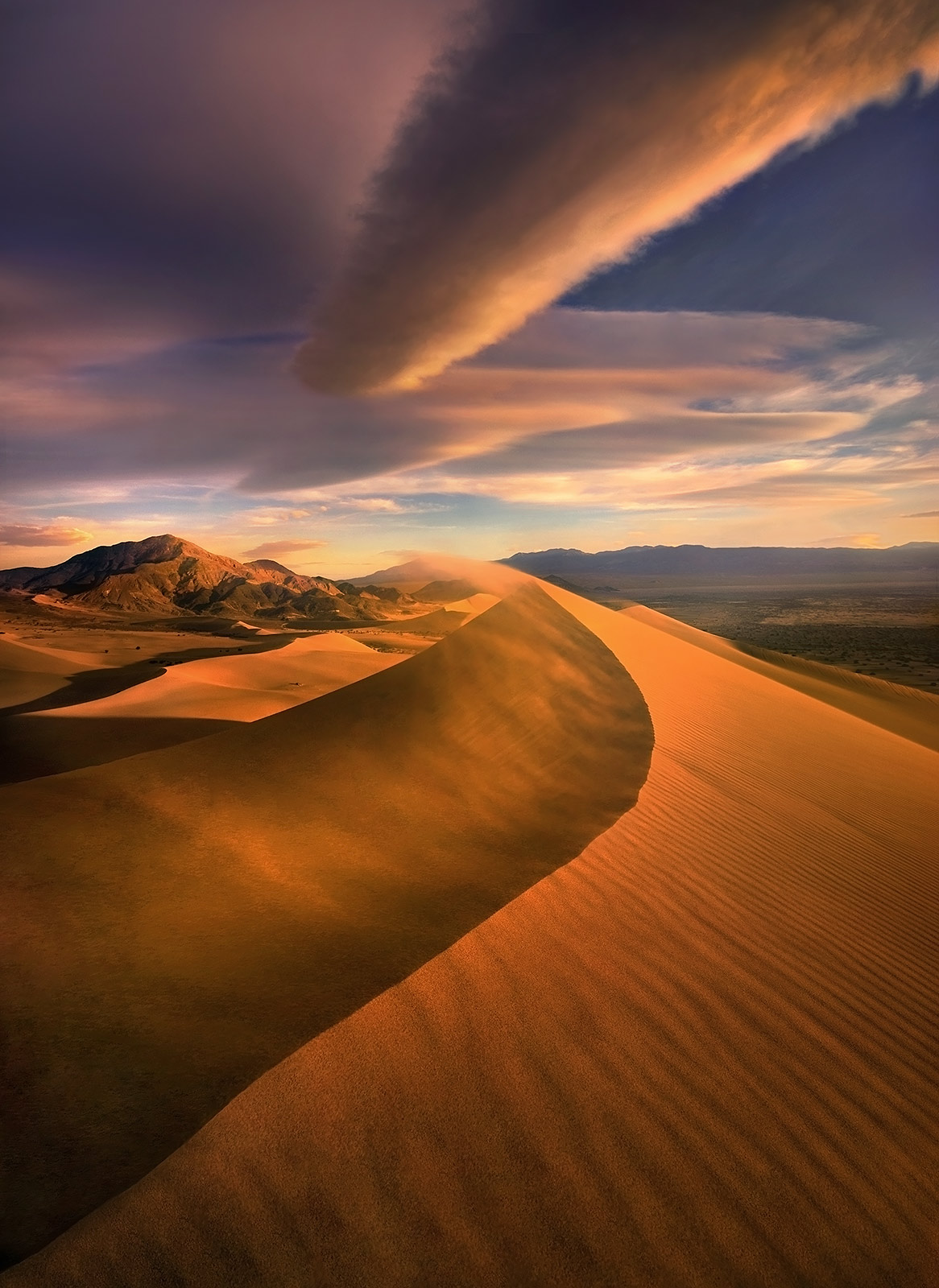 An amazing show of light and skies over wind-swept dunes catching the sunset in Death Valley.