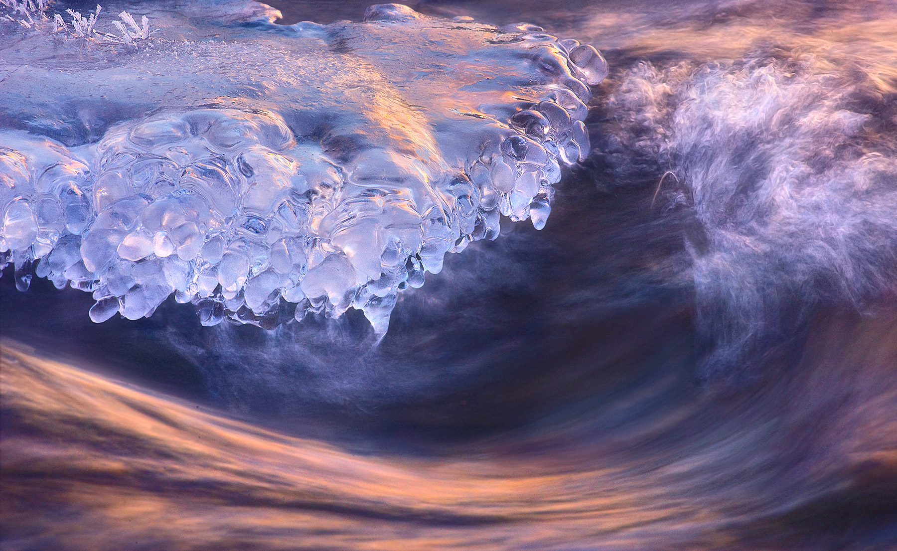 Reflected sunrise light on the Bow River and ice formations. Winter in Alberta.