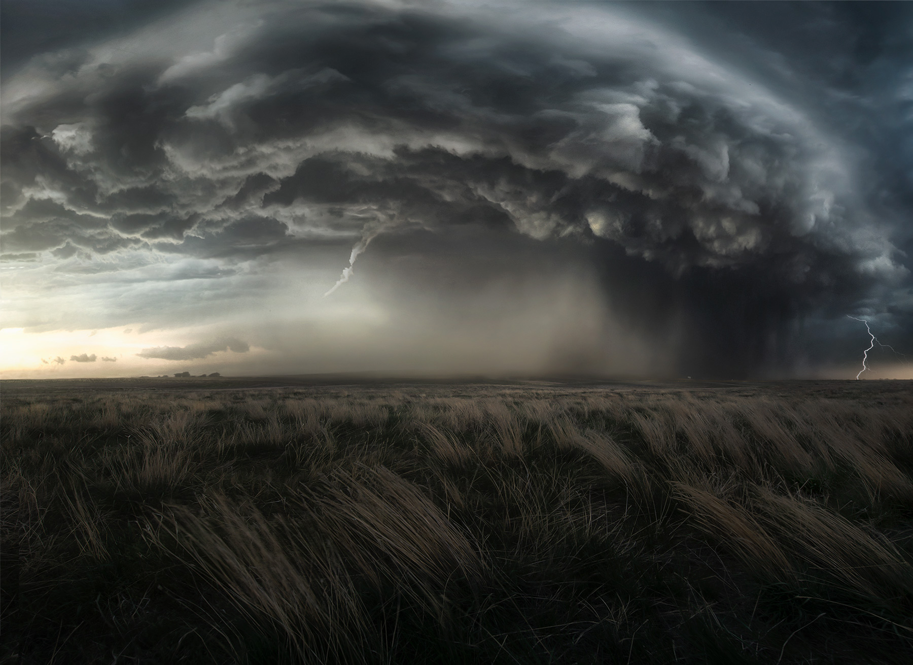 Supercell thunderstorm on the plains above wind swept fields